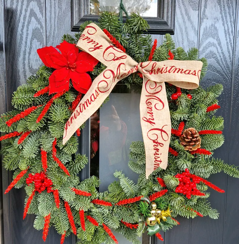 Świąteczny wieniec na drzwi z czerwoną kokardą „Merry Christmas”