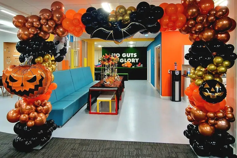 Halloweenowa brama z balonów z dyniami w czerni i pomarańczu