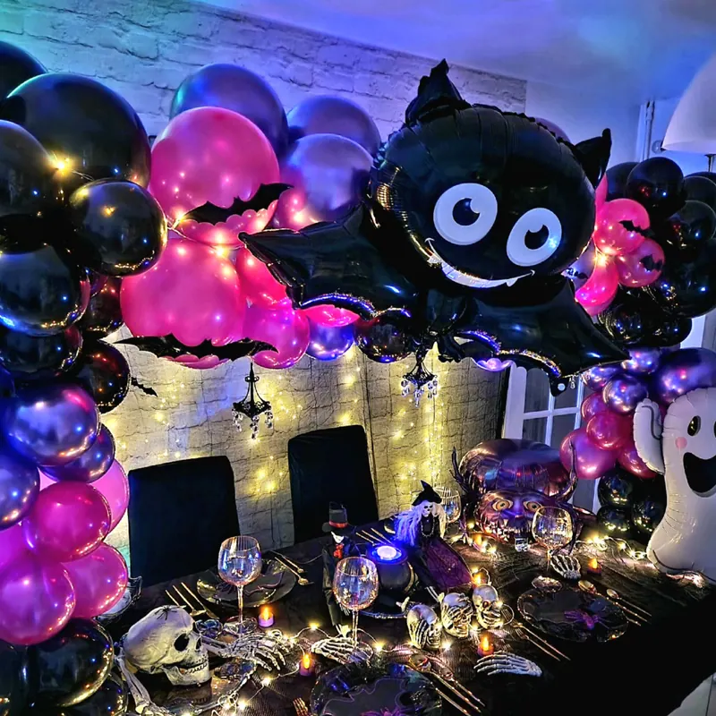 Halloweenowa dekoracja stołu z balonem-nietoperzem i fioletowymi balonami