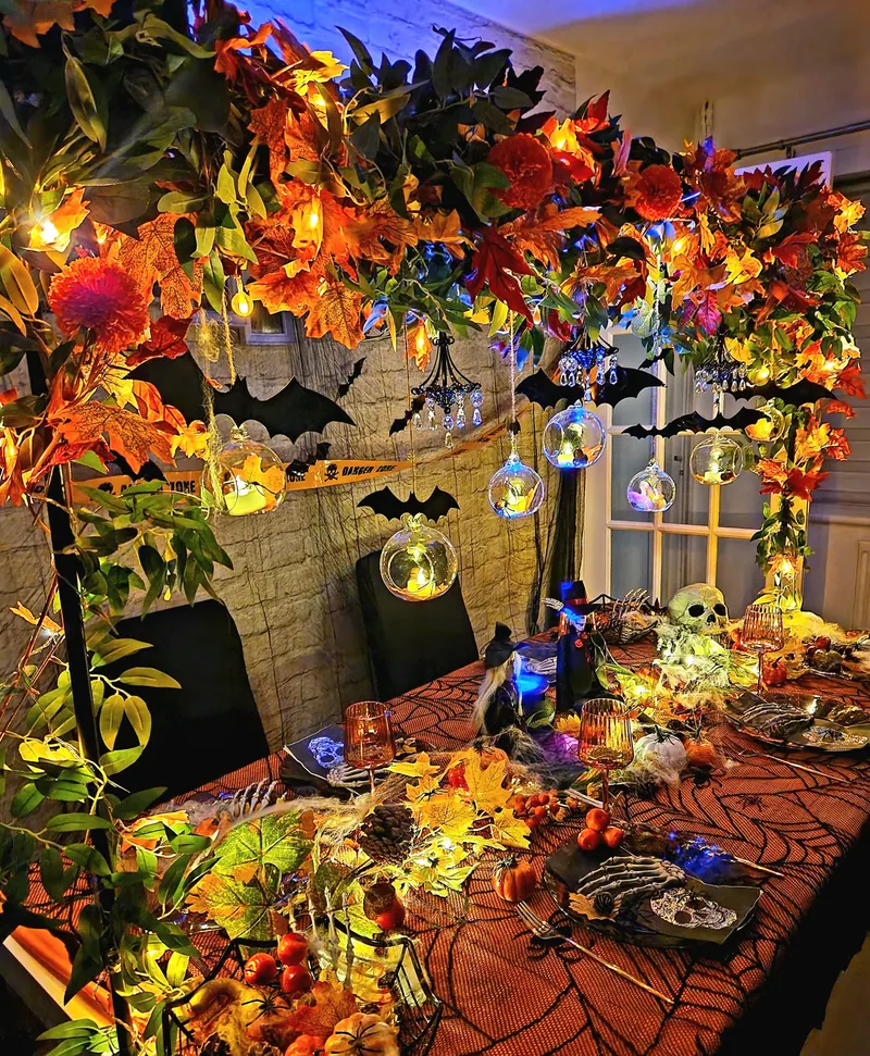 Halloweenowa girlanda z jesiennych liści i lampionów nad stołem