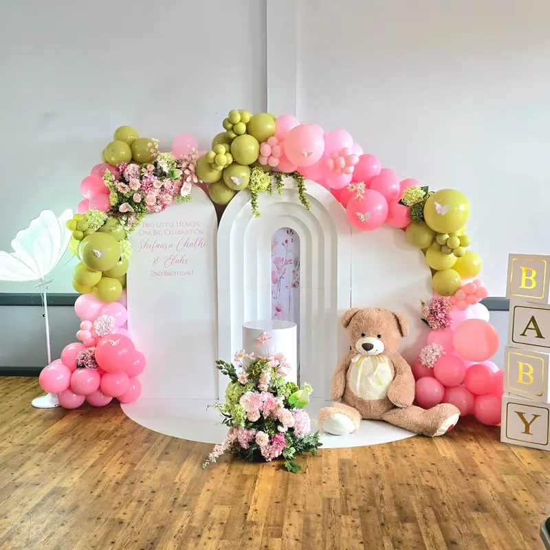 Dekoracja na baby shower z różowo-oliwkowymi balonami i pluszowym misiem