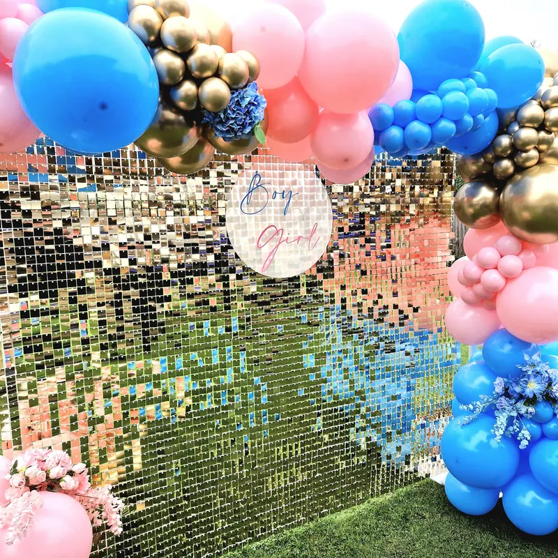 Złota ścianka cekinowa z różowo-niebieską girlandą balonową na baby shower