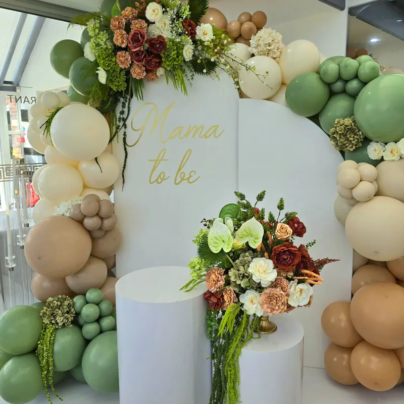 Dekoracja na baby shower „Mama to be” z zielono-beżowymi balonami i kwiatami