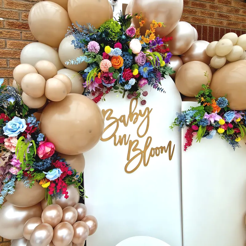 Ścianka „Baby in Bloom” z beżowymi balonami i kolorowymi kwiatami